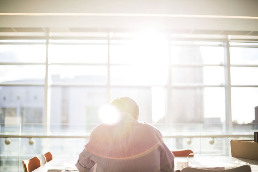 Sun shines on a man sitting at office table