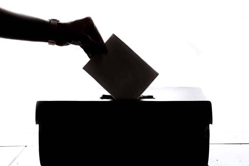 A silhouette of a ballot being dropped into a ballot box