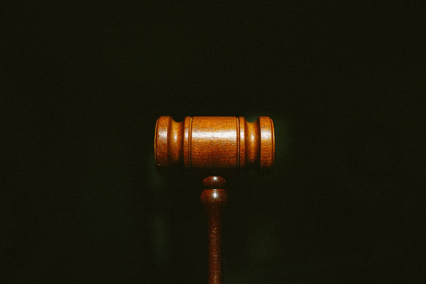 A wooden gavel against a black background