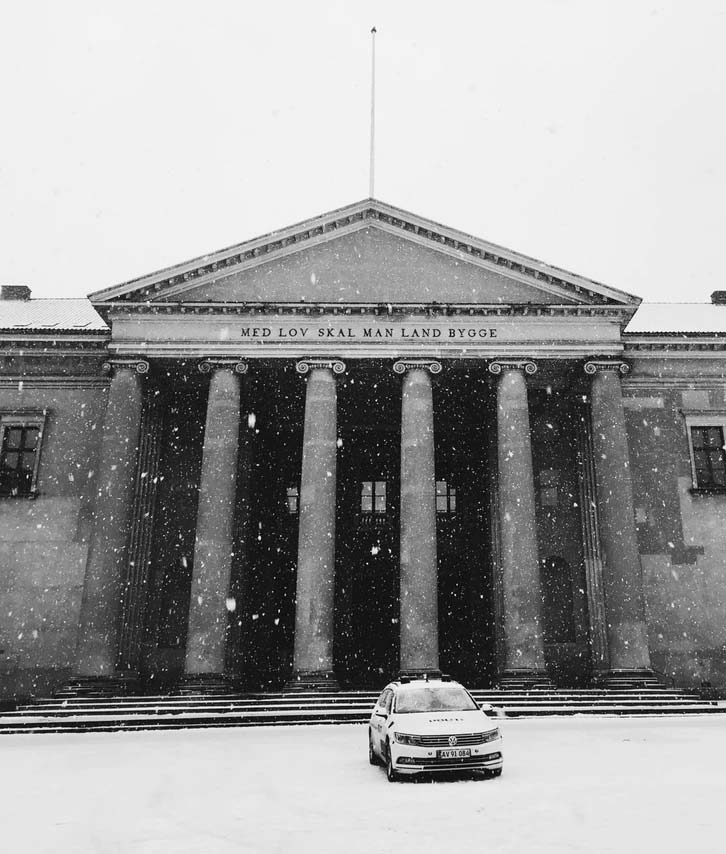 Court building covered in snow with car parked out front